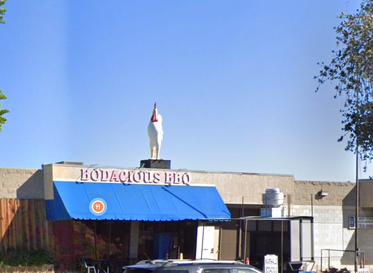 White chicken statue on the roof of Bodacious BBQ.